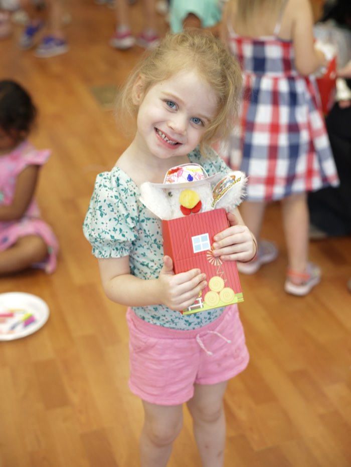 A preschooler holding up her barn craft