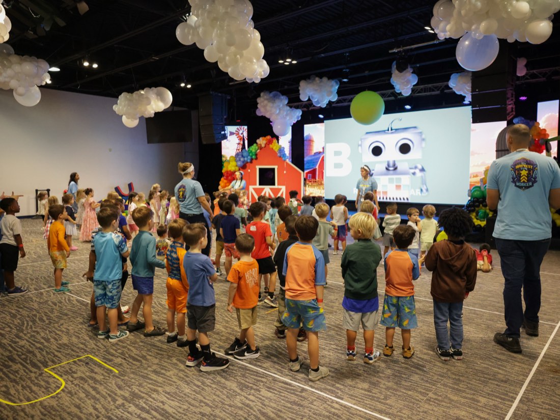 A toddler on stage in front of the barn screen
