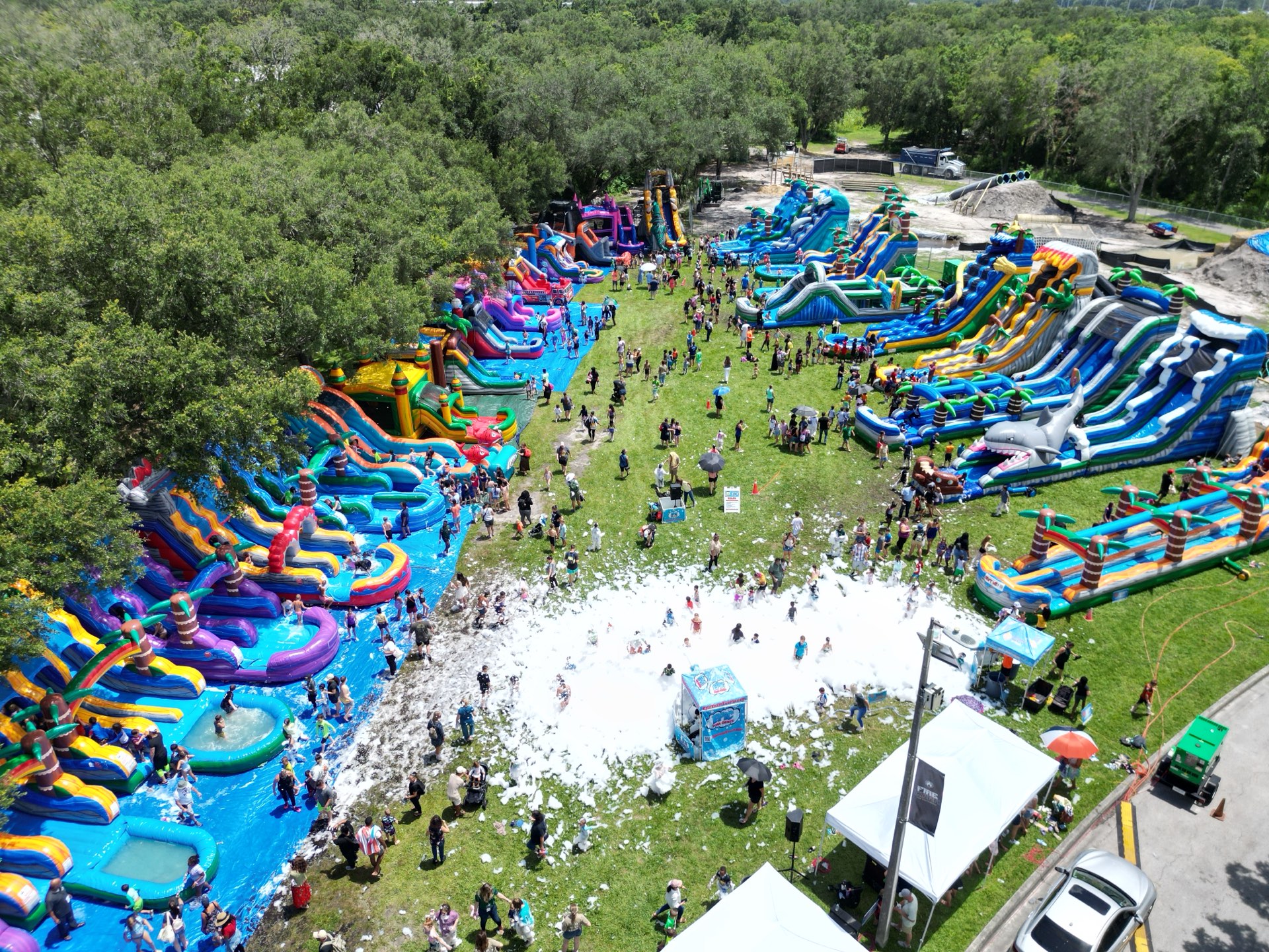 Aerial view of the Water Day field packed with inflatable water slides and a foam pit